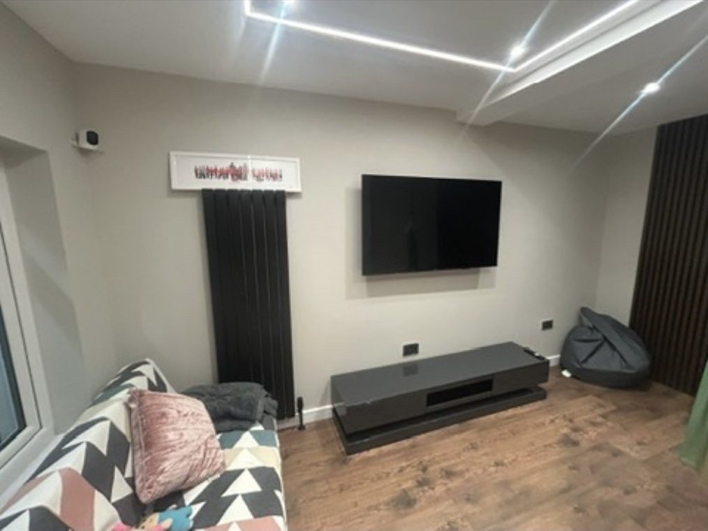 Garage conversion media room with wall-mounted TV and premium storage unit